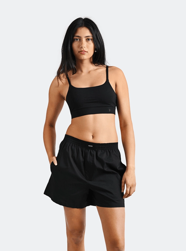 Model in a black bralette and black Woxer shorts
